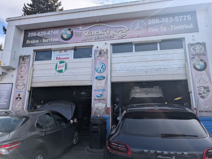 The two service bay doors at Zack's Auto Service, with the shop sign above them and manufacturer banners along the sides.